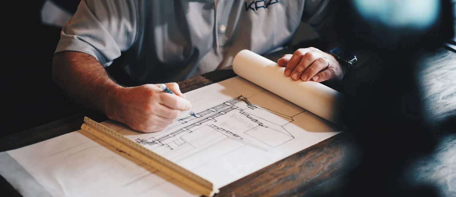 Hand zeichnet einen technischen Plan auf Papier